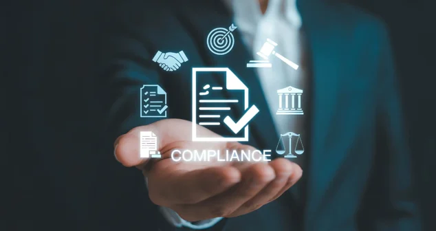 Businessman holding a glowing compliance icon with legal and regulatory symbols, representing REACH SVHC compliance for medical device manufacturers