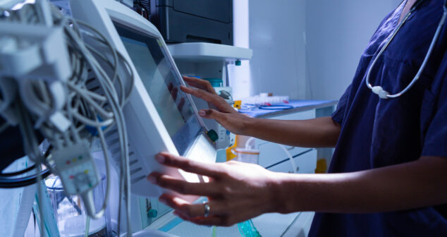 Service Design Medical Device Development Description: Healthcare worker looking at screen of her equipment