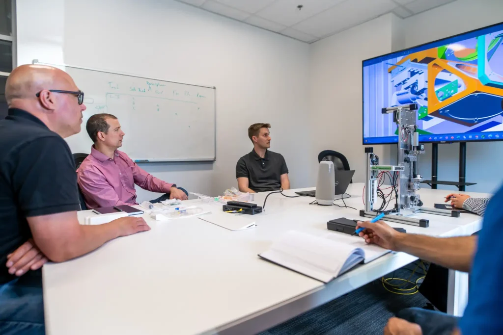 Design review meeting evaluating a 3D concept rendering for a medical device