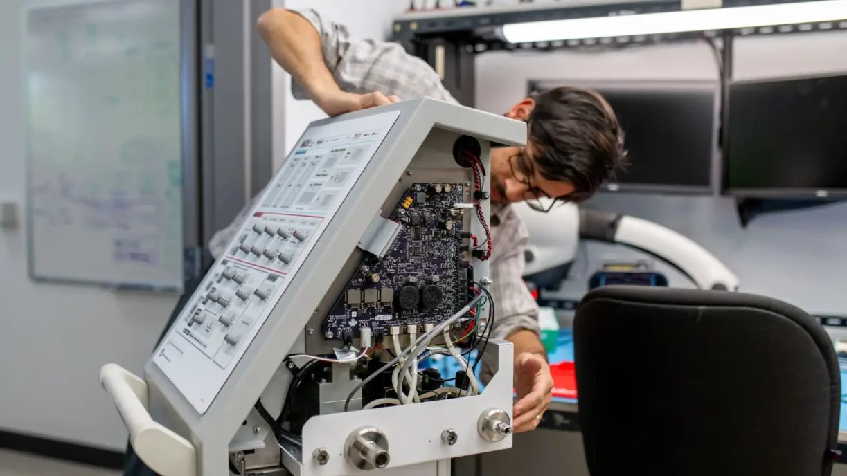One engineer works hands-on with this board's internals, carrying it from design through bring-up