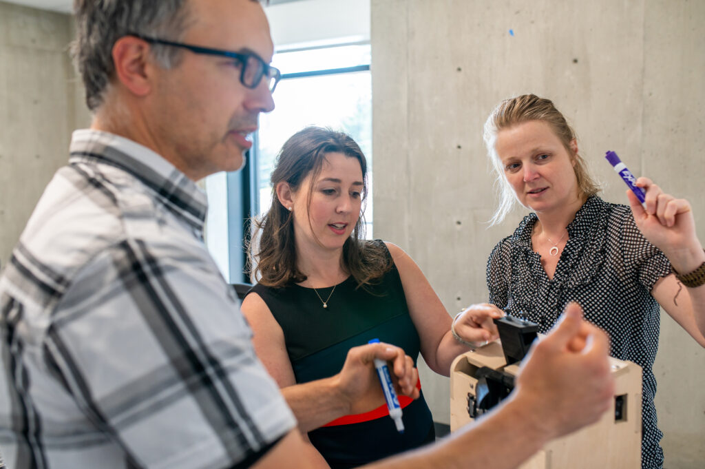 Cross-functional team inspecting a therapy device prototype together