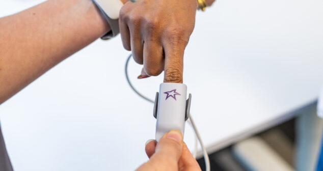 Clinician applying a fingertip sensor with StarFish logo during usability testing